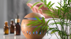 Modern aroma oil diffuser on the white table. Spa concept for body and health care. female is adding essential oil to an aroma diffuser